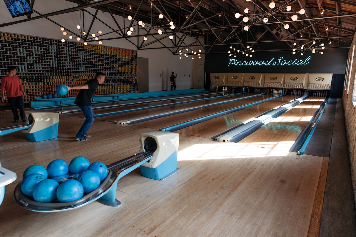 men bowlinig at the Pinewood Social bowling alley